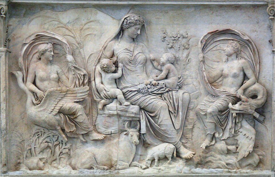 Rilievo dell'Ara Pacis raffigurante una figura femminile con due bambini, affiancata da personificazioni allegoriche